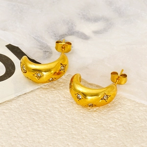 Close-up of golden C-shaped stainless steel earrings with star-set zircon detailing