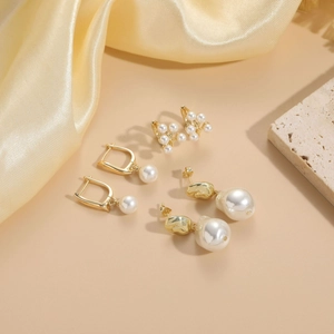 Detailed close-up of three pearl earring styles in 14K gold-plated copper material