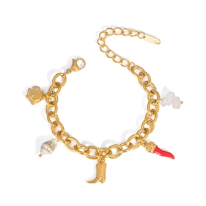Detail of gold stainless steel bracelet with shell, fish, and pink stone charms