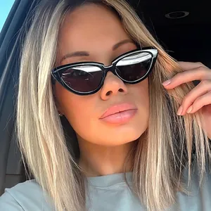 Women's black cat-eye sunglasses with dark lenses shown in a realistic driving setting
