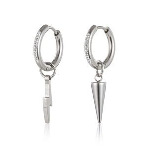 Close-up of asymmetric silver earrings with lightning and spike charms and small crystals