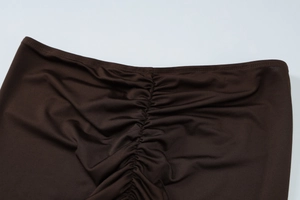 Close-up of ruched detail and fabric texture on dark brown summer slim fit two-piece set