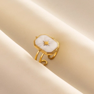 Gold eight-pointed star open ring with white rectangle inlay on silk fabric