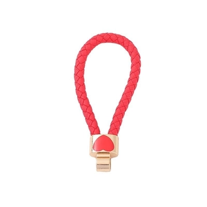 Close-up of red woven leather rope keychain with gold metal clasp and heart detail