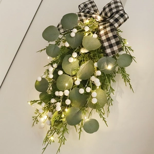 Christmas Eucalyptus wall hanging with white berries, buffalo plaid bow, and warm LED lights