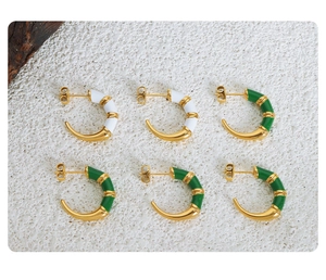 Detailed macro view of white and green enamel bamboo-style C-shape stud earrings