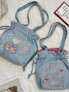 Denim drawstring tote bag with embroidery and red gingham lining in light blue