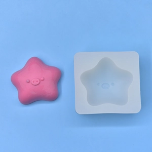 Macro detail of star pig silicone mold and finished pink resin craft on blue background