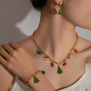 Christmas jewelry set with gold enamel tree and star charms worn by a model