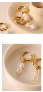 Detailed macro view of vintage 18k gold earrings with dangling natural baroque pearls
