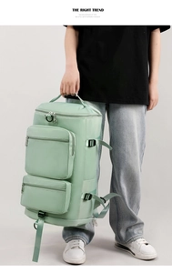 Light green fitness bag with multiple pockets and adjustable straps shown with model