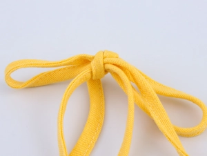 Detailed macro view of yellow braided cotton drawstring straps with knotted texture
