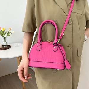 Pink crocodile pattern dome bag with golden hardware and adjustable crossbody strap