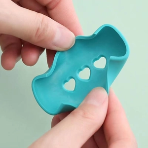 Flexible teal silicone pot handle cover with heart-shaped cutouts for heat insulation