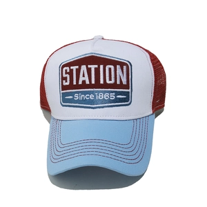 Close-up of STATION 1865 embroidery and red mesh detail on a vintage trucker hat