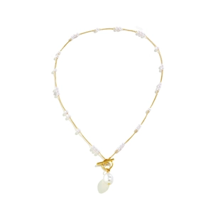Detail of gold chain necklace with white baroque pearl pendant and leaf-shaped charm
