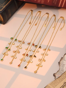 Detailed flat lay of golden teardrop tassel necklaces with multi-color crystal gemstones