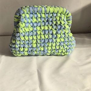 Detail of light blue and lime yellow crochet cloud bag with thick woven texture