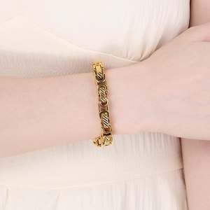 Gold stainless steel curb chain bracelet with twill texture worn by model
