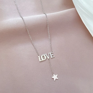Close-up of silver titanium steel necklace featuring LOVE pendant and star charm on silk