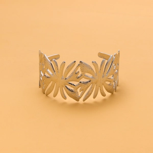 Detail view of silver stainless steel cuff featuring hollow leaf and feather filigree design