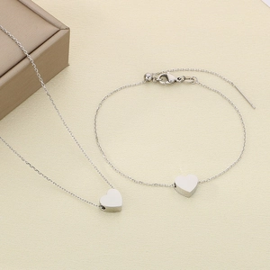 Vue détaillée du collier et bracelet avec pendentif cœur en acier inoxydable argenté et écrin