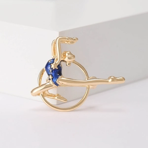Detail view of rhythmic gymnastics brooch with blue enamel on a white stand