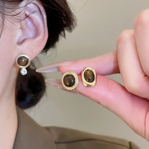 Close-up of vintage tiger eye geometric stud earrings with gold plating and fine crystals