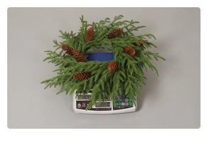 Weight measurement of a 30cm green pine needle Christmas wreath with natural pine cones