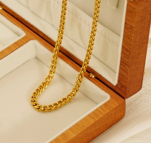 Detailed macro shot of a golden Cuban link chain displayed in a wooden premium jewelry box
