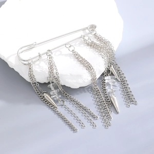 Detail of silver safety pin brooch with multi-layered metal chains and conical charms