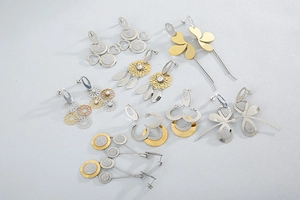 Flat lay of multiple daisy flower and geometric earrings in gold and silver finish