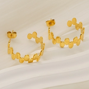 Détails des boucles d'oreilles C dorées avec pièces ovales superposées sur pierre blanche