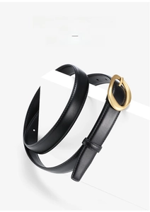 Macro detail of black leather belt with gold alloy buckle on minimalist geometric stand