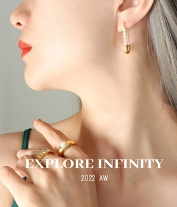 Detail of model wearing gold paperclip pearl earrings and elegant zircon rings