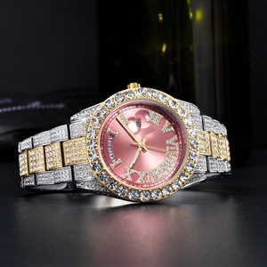 Macro shot of iced-out silver gold watch with pink dial showing day and date
