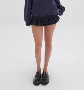 Detail of dark blue plaid pleated mini skirt paired with black platform loafers