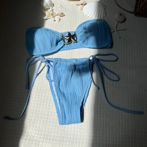 Detail of light blue bikini featuring a silver starfish buckle and ribbed fabric texture