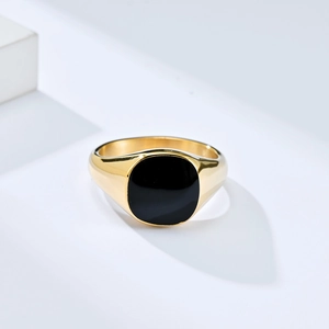 Macro detail of gold-plated titanium signet ring with smooth black enamel inlay surface