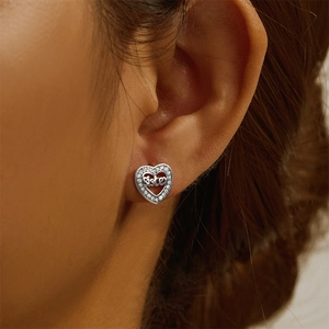 Close-up of S925 sterling silver heart earring with Sister engraving and zircons