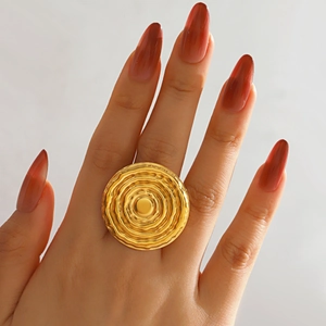 Minimalist gold stainless steel ring with round concentric ripple texture worn on hand
