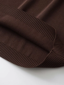 Detailed close-up of dark brown knit fabric showing ribbed cuffs and soft texture