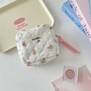Close-up of quilted sanitary napkin bag with brown bear patterns and pink cord zipper pull