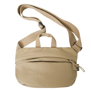 Detailed close-up of beige nylon crossbody bag with adjustable wide strap and buckle