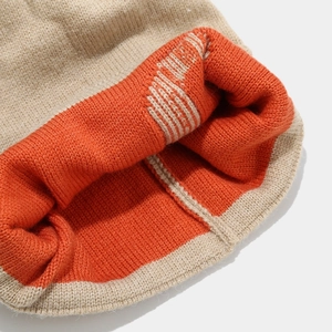 Macro detail showing thick ribbed knit texture and khaki and orange double-layer stitching