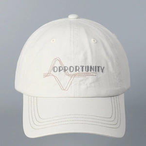 Detail of cotton baseball cap featuring OPPORTUNITY embroidery and curved brim