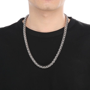 Detail of silver stainless steel wheat chain necklace worn on a male model with black t-shirt