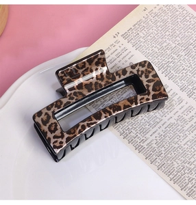 Detailed view of square leopard print hair claw clip on vintage aesthetic background