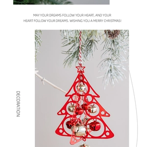 Detail of red hollow Christmas tree ornament with festive gold bells hanging on pine branch