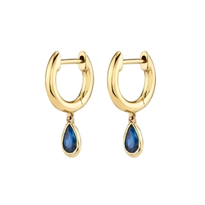 Detail of gold hoop earrings featuring teardrop-shaped dark blue cubic zirconia stones